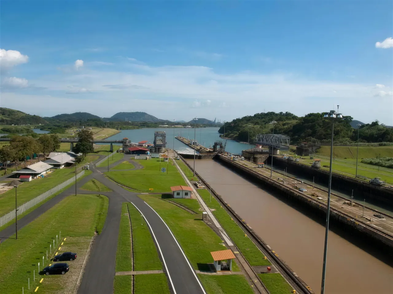 Panama Canal lock chambers and approach channel seen from above, framed by tropical hills