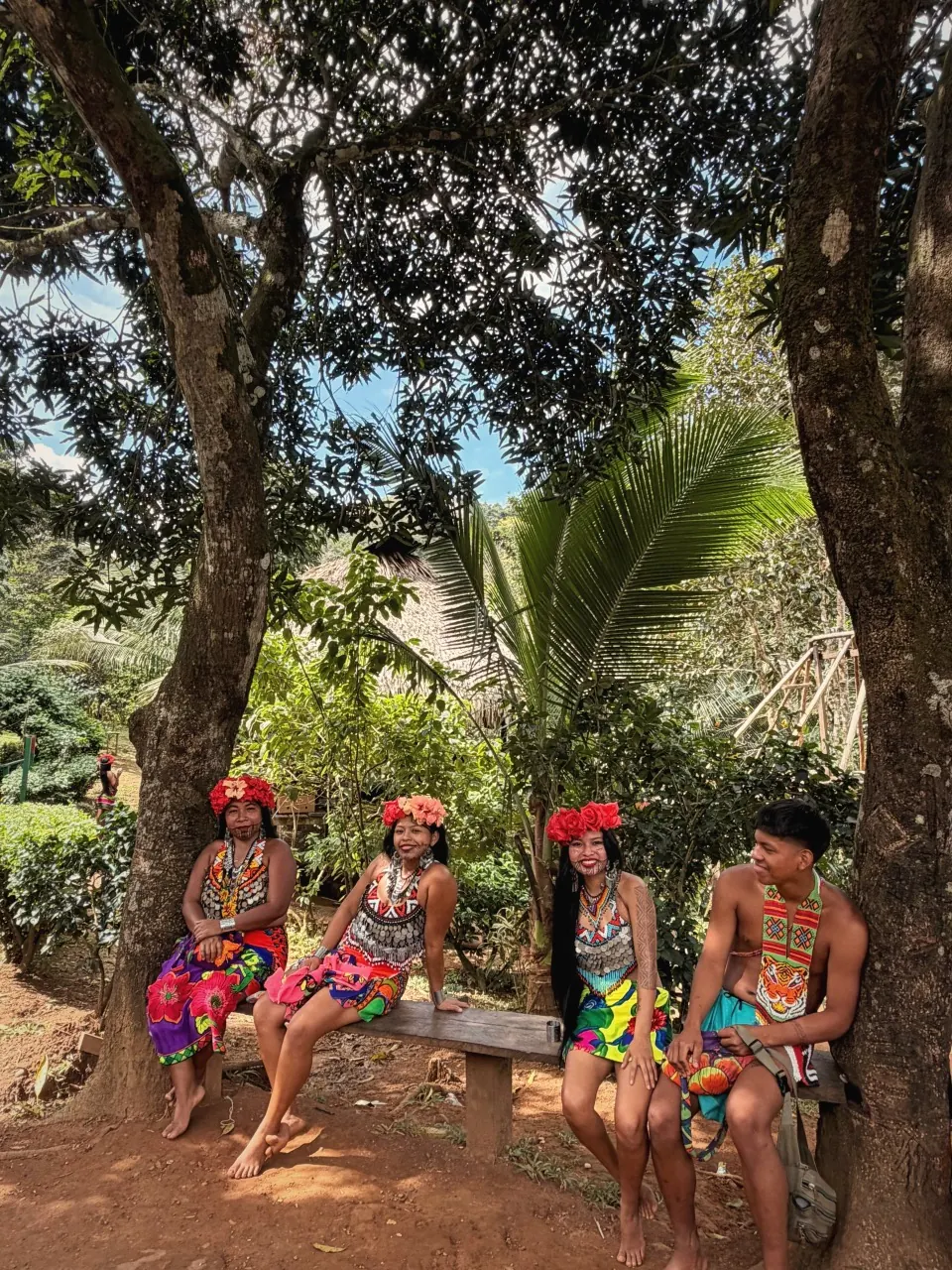 Embera community members in traditional beaded dress and molas in their rainforest village