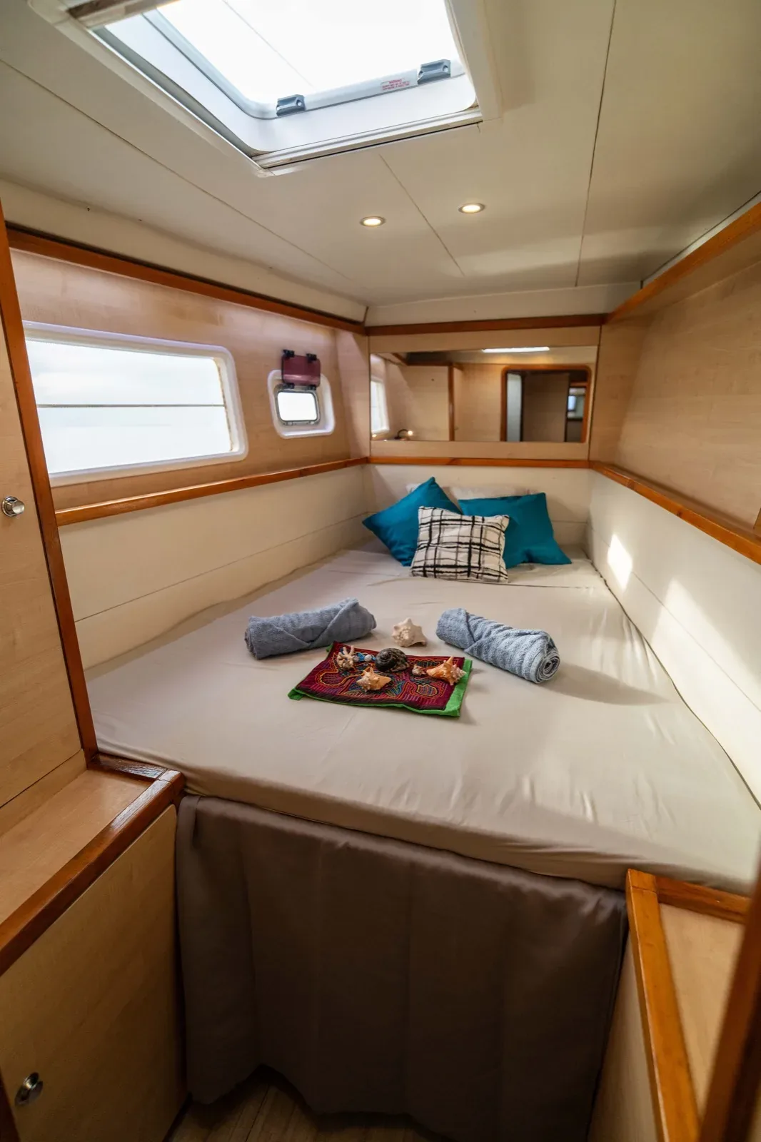 Double cabin on the Lagoon 450 with an overhead hatch, rolled towels and a Guna mola runner