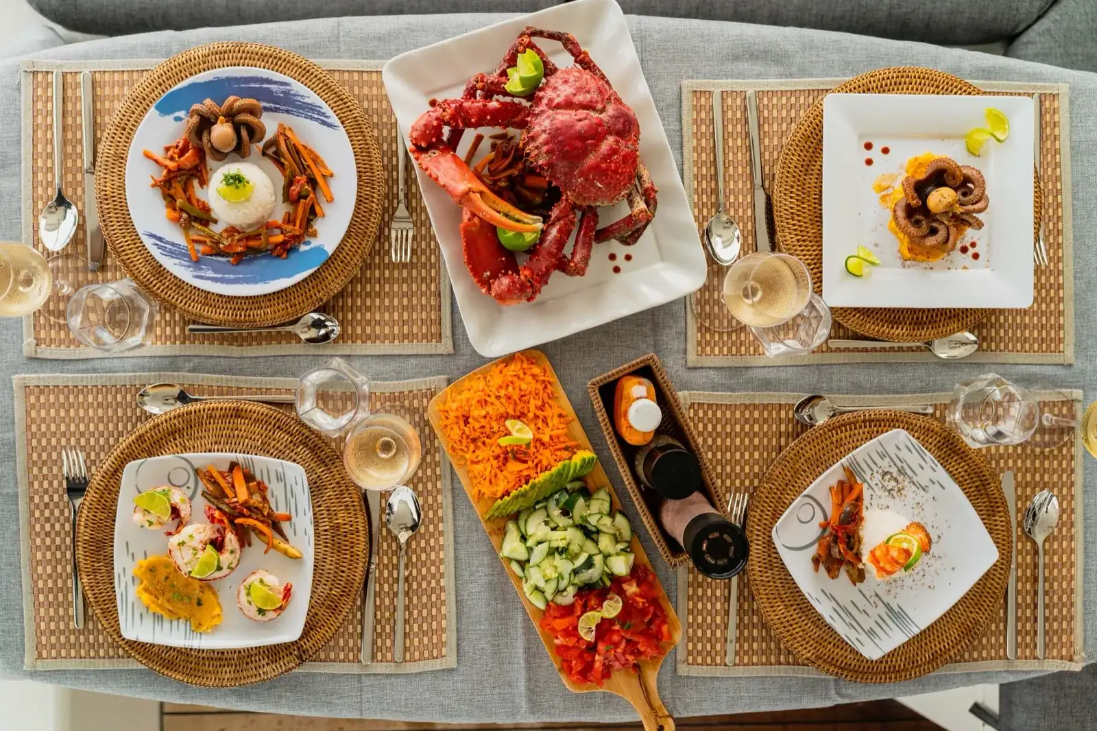 Overhead view of lunch on the Lagoon 450: whole crab, plated octopus, rice and salads
