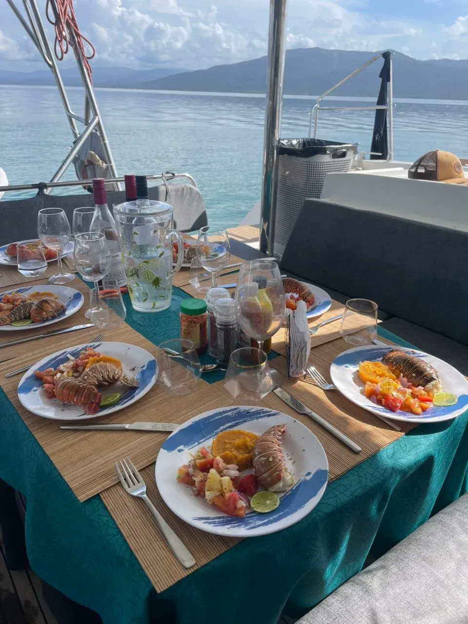 Lobster lunch served in the cockpit of the Lagoon 450 with the mainland hills behind