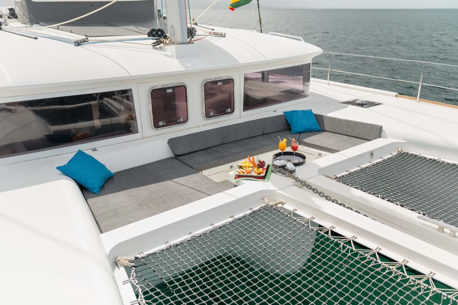 Bow trampolines and sun pads on the Lagoon 450 with cocktails and a snack tray served on deck