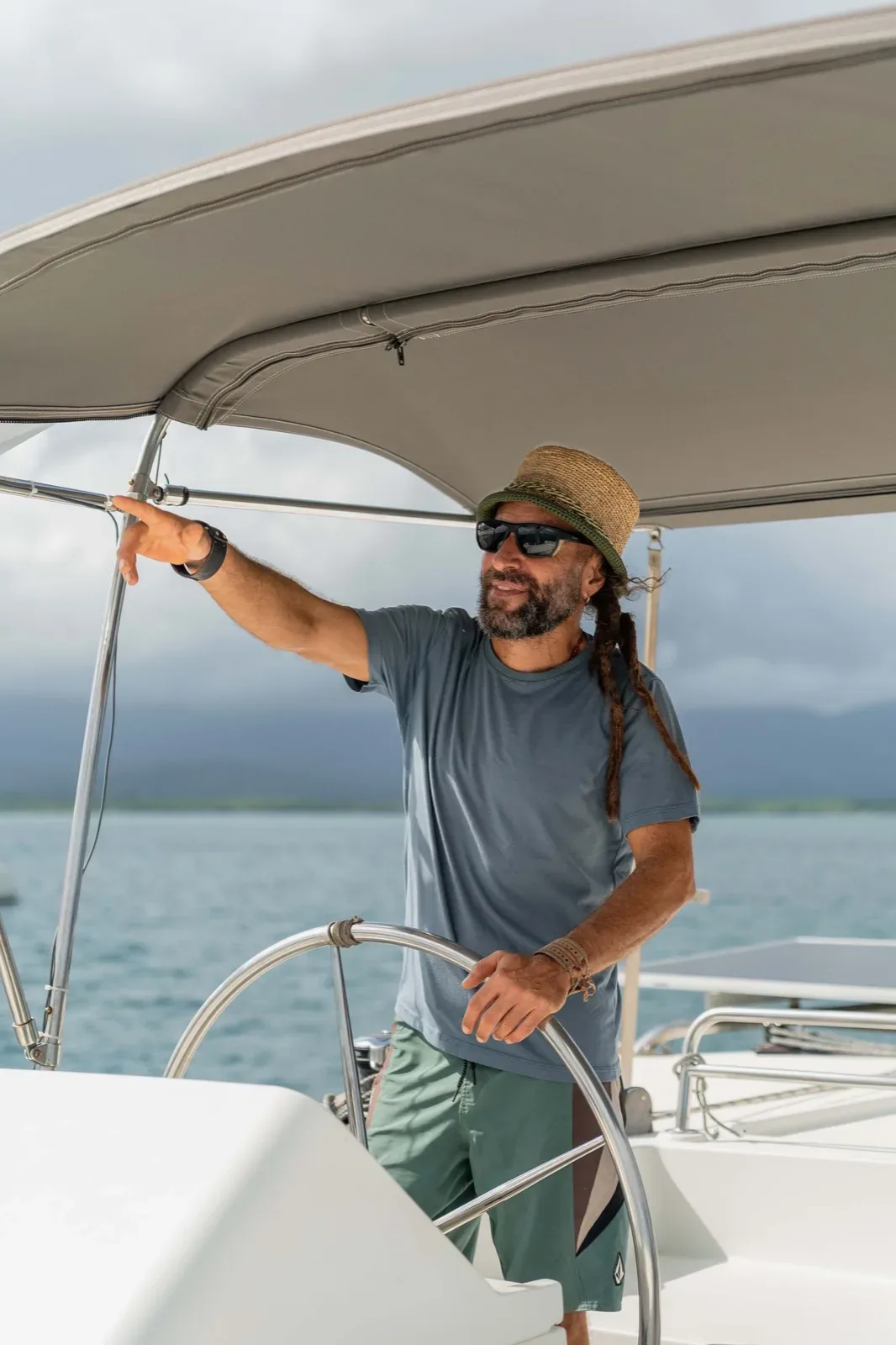 The captain steering the Lagoon 450 from the helm station under the bimini