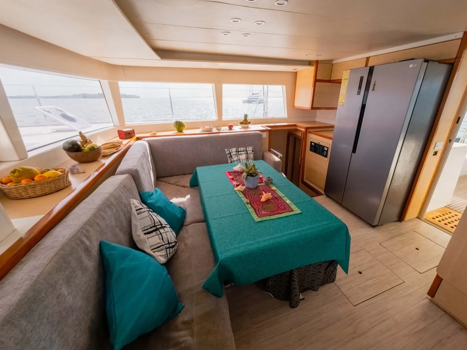 Salon and galley of the Lagoon 450 with a full-height stainless fridge and fruit bowl