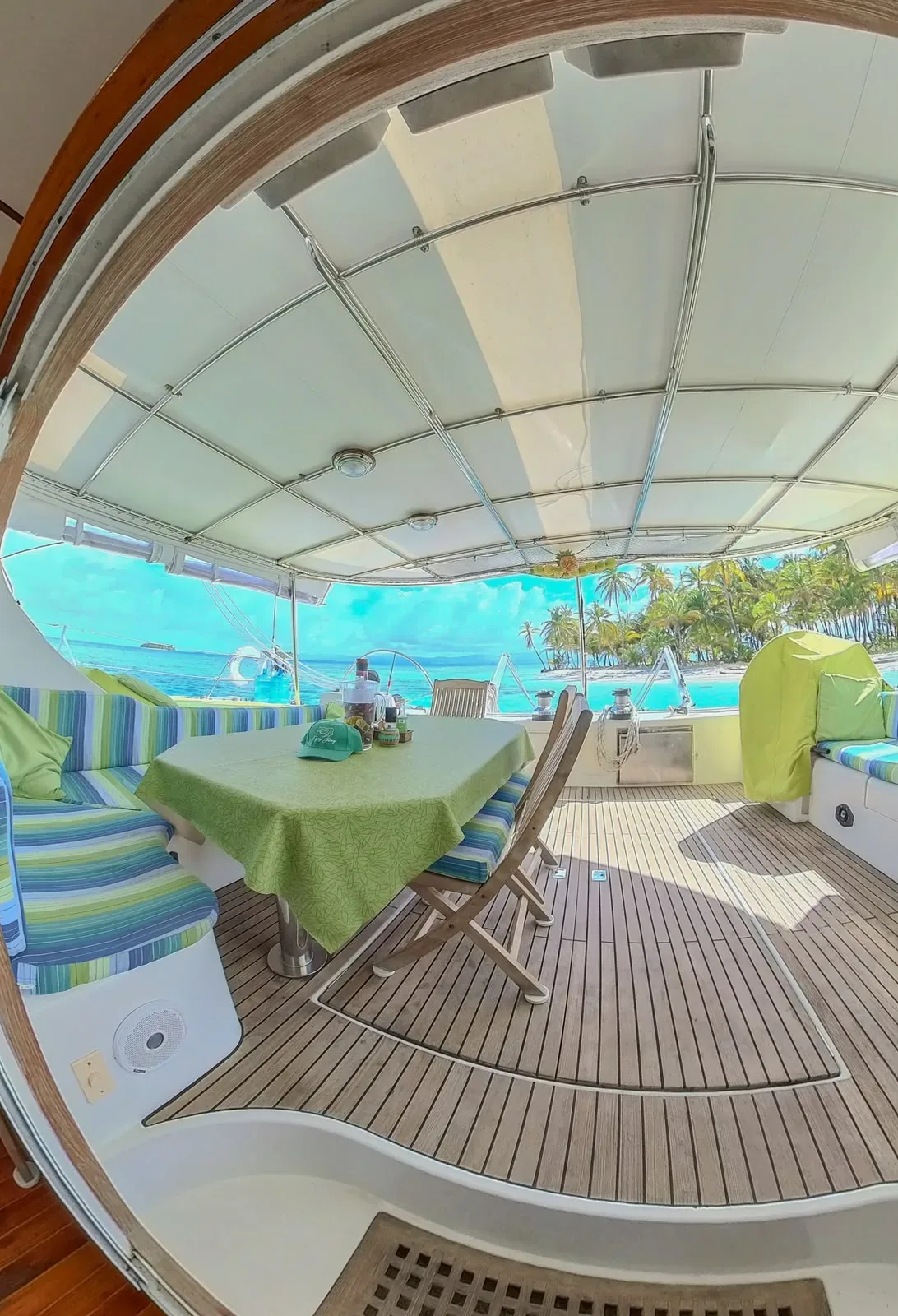 Cockpit dining area of the Lagoon 55 set for a meal, looking out to a palm island