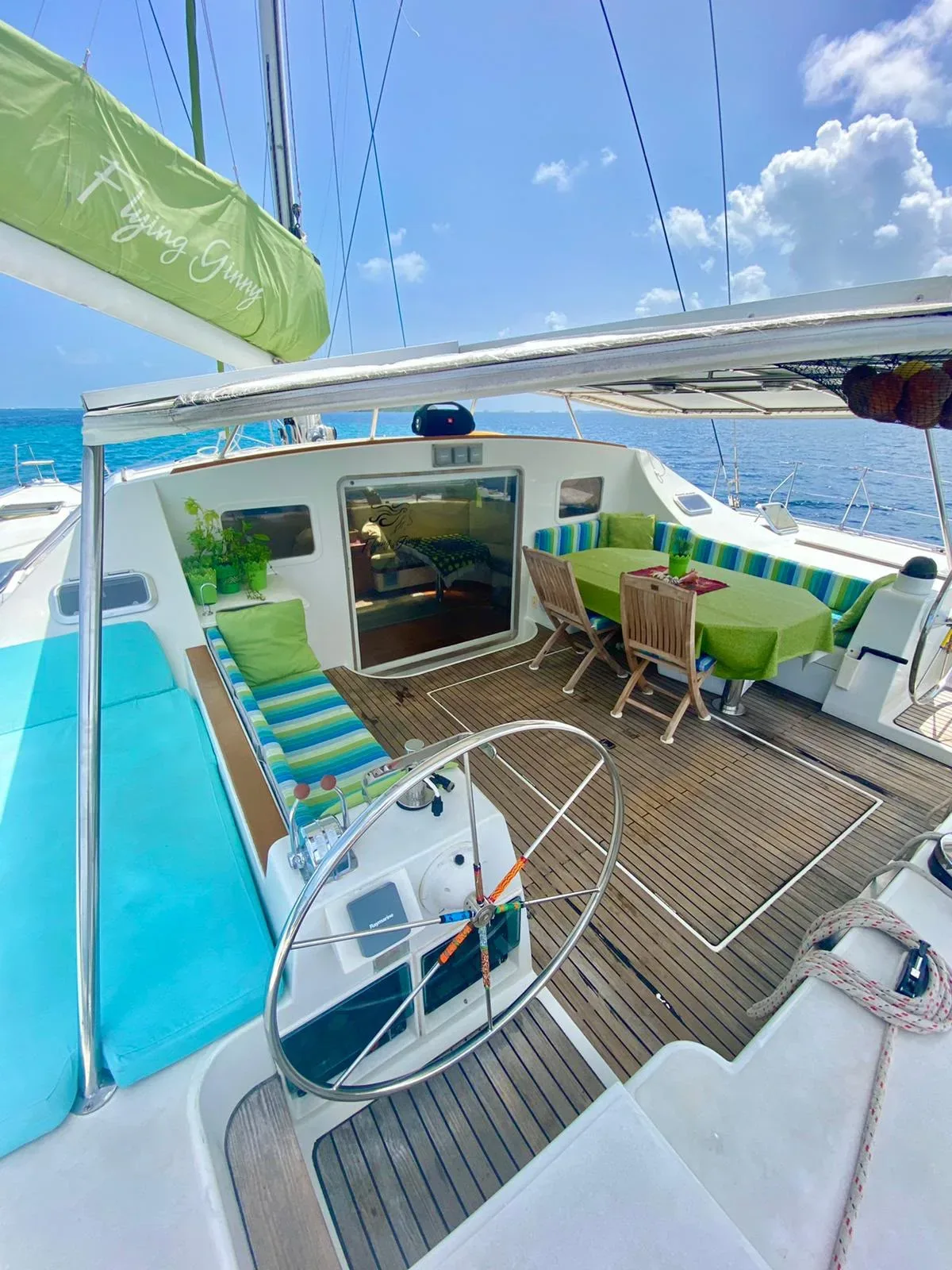 Helm and cockpit of the Lagoon 55 with the dining table set and teak decks