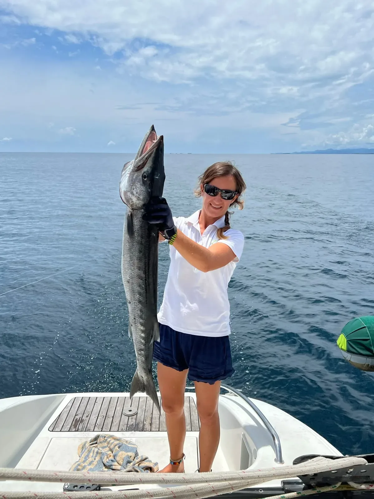 Crew holding a barracuda caught from the Lagoon 55 on the way to the islands