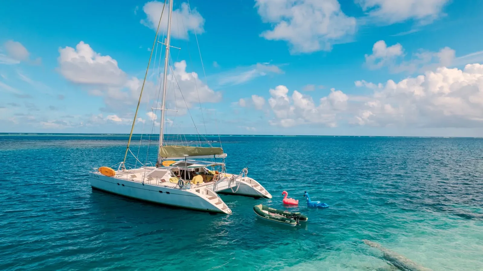 The Lagoon 55 on clear turquoise water in Guna Yala with the dinghy alongside