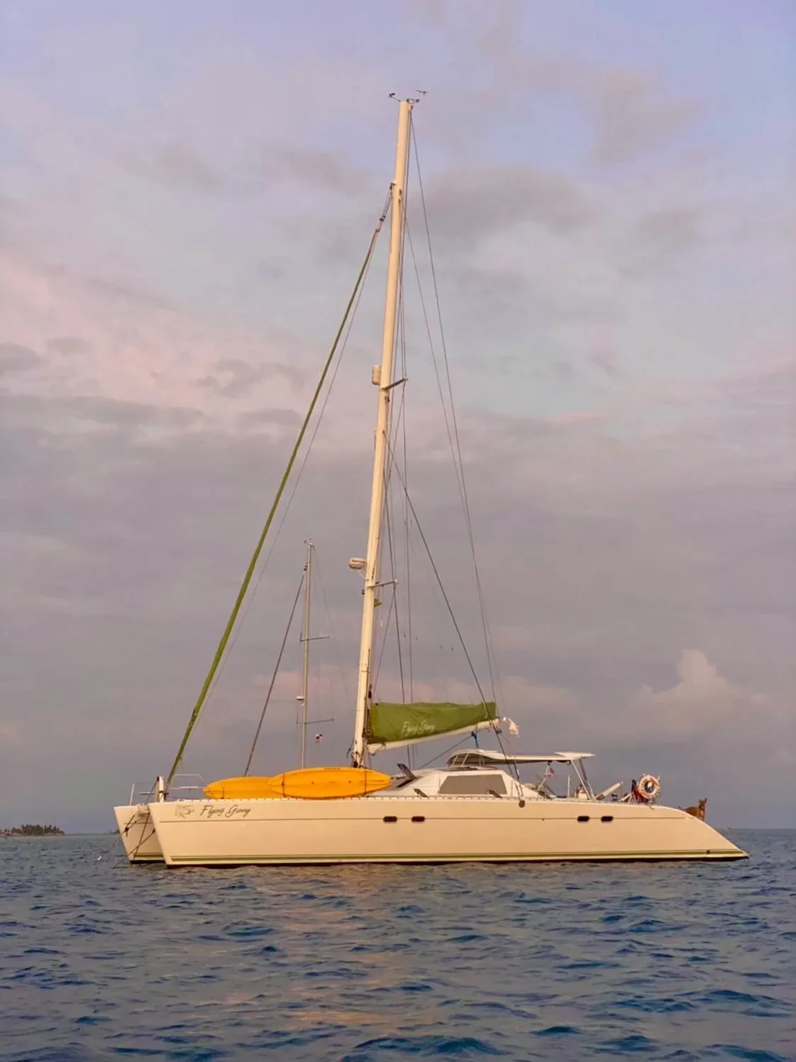 The Lagoon 55 at anchor at dusk under a pink sky in the San Blas Islands