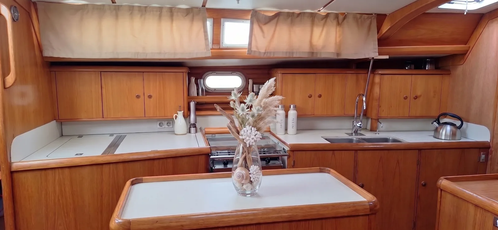 Galley with a gas stove, a double sink and wooden cabinets