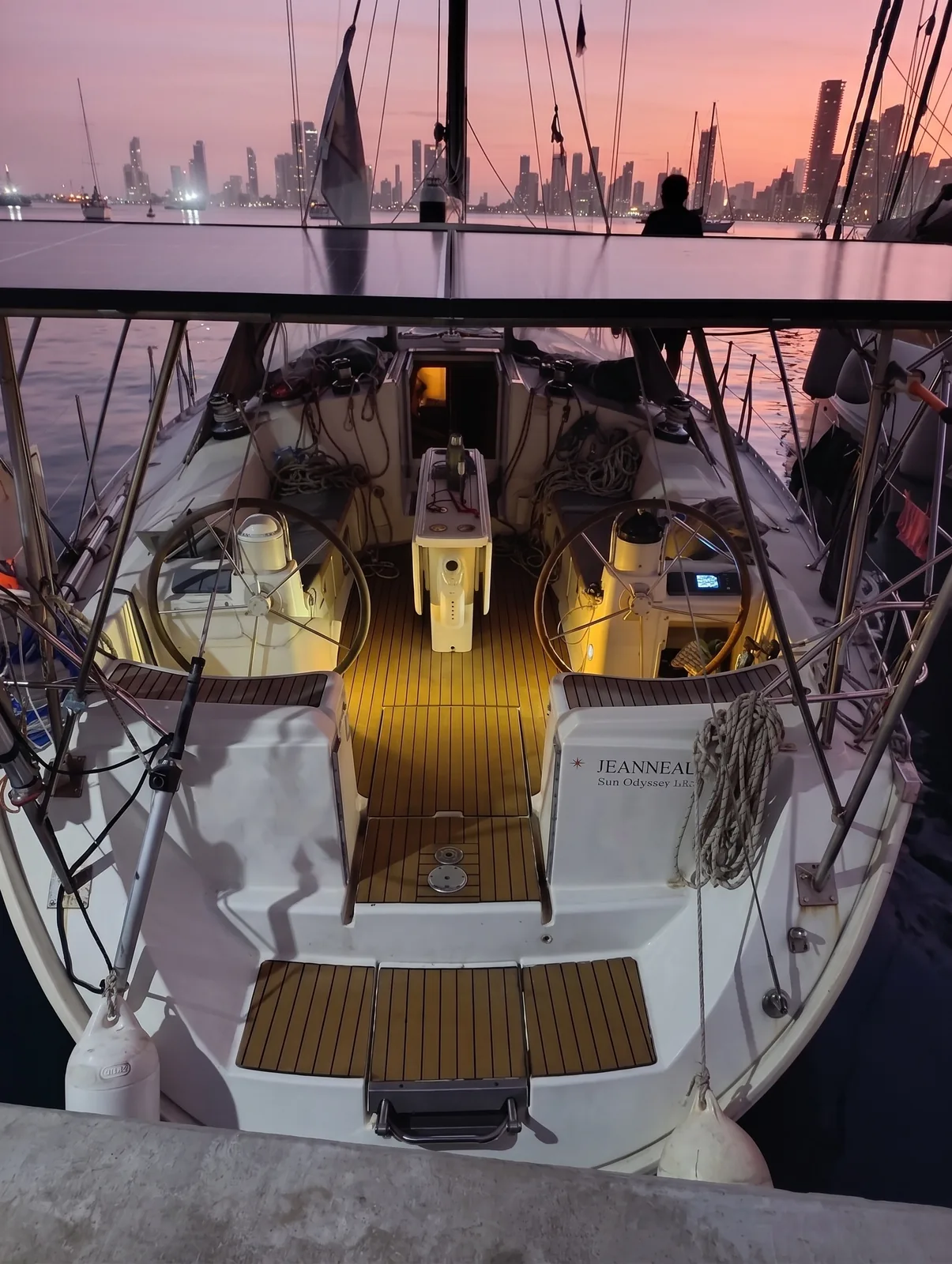 Cockpit of the Jeanneau 45.2 at dusk, twin wheels and teak deck lit from below, moored stern-to