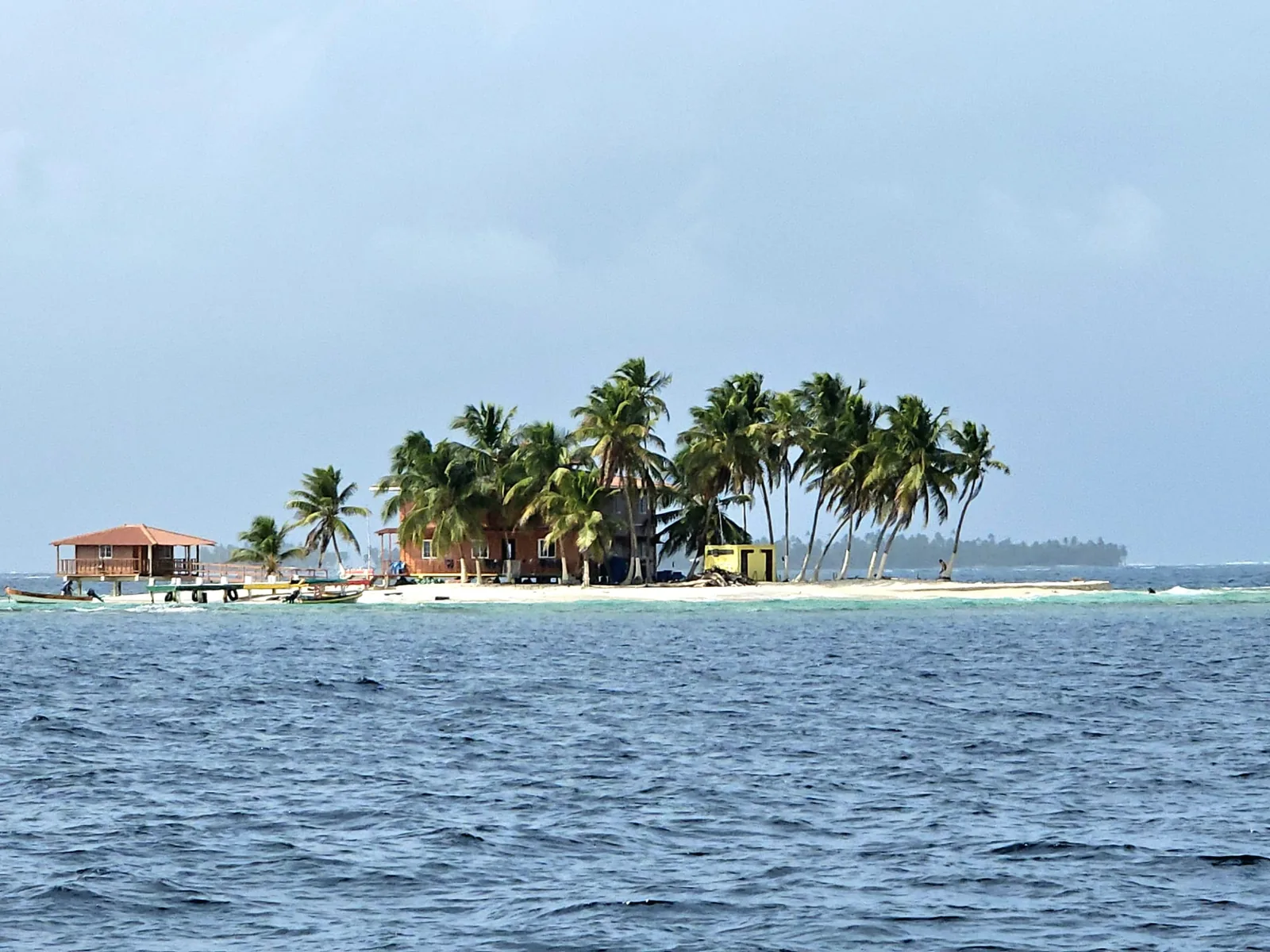 Small San Blas island with palm trees and a wooden house on the water