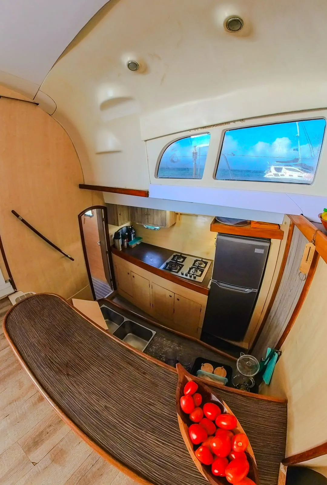 Galley with a stove, fridge and a curved wooden counter