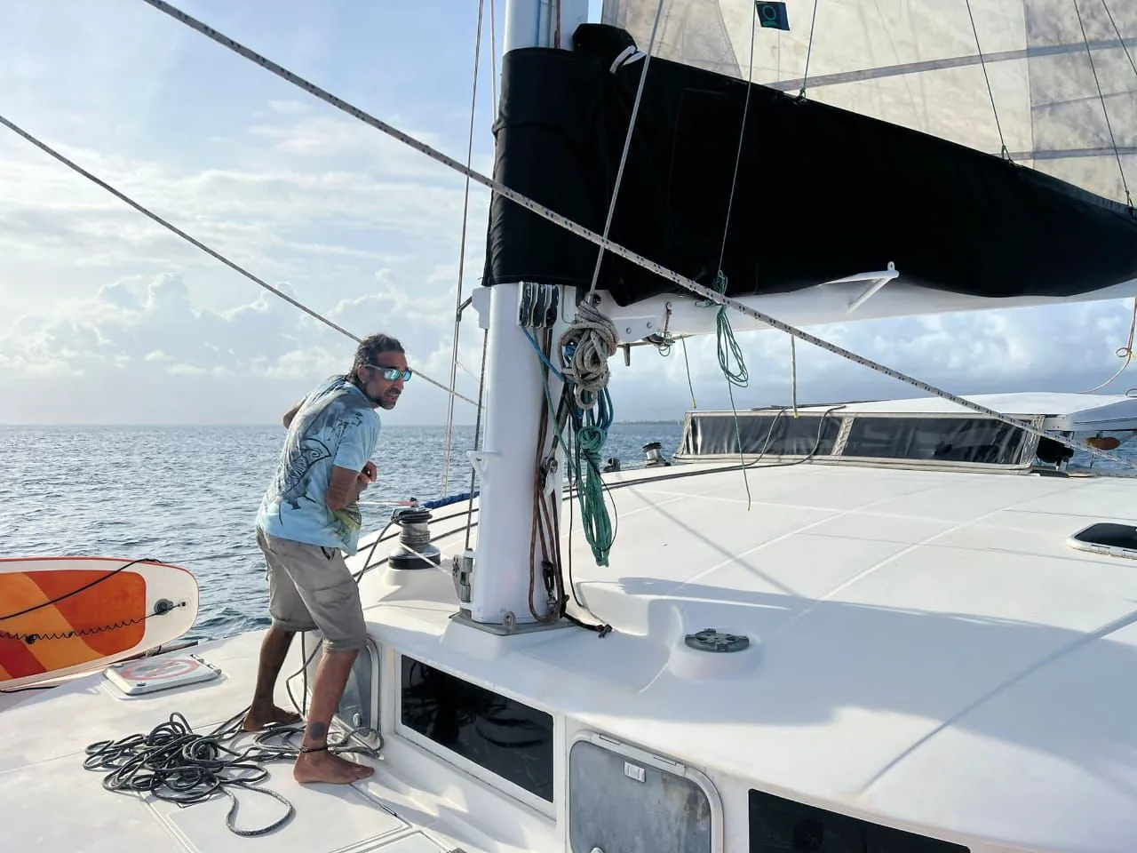 A crew member on deck, sails furled