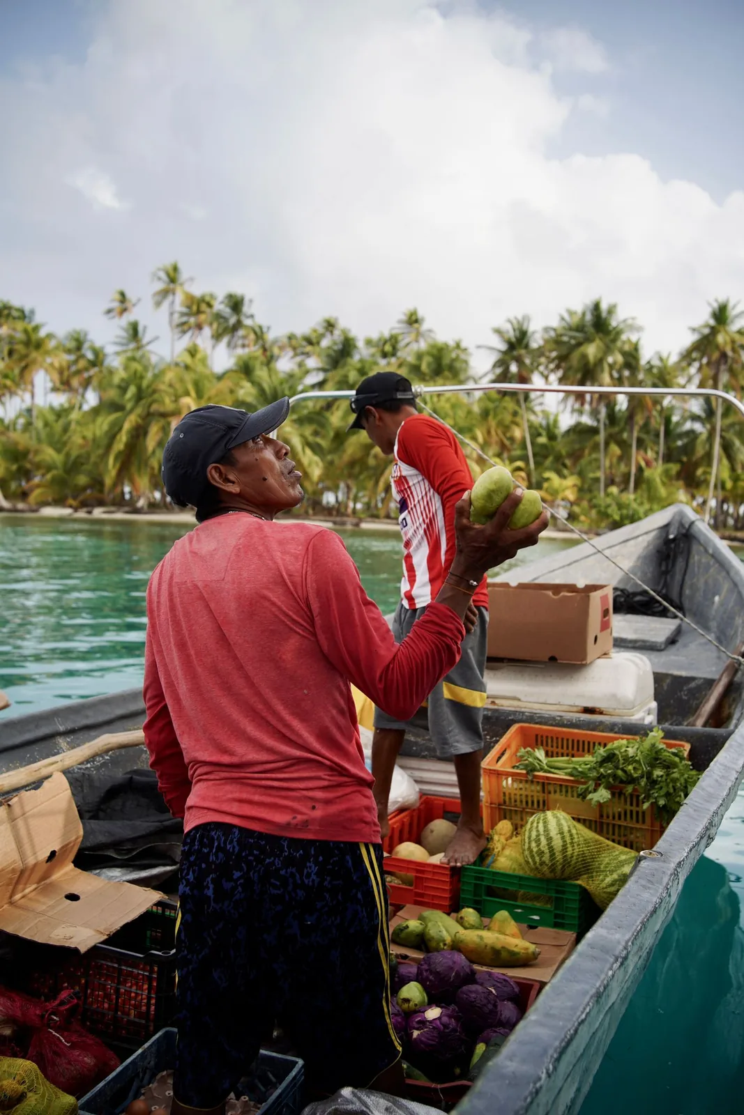 Local vendors selling fruit and vegetables from a boat