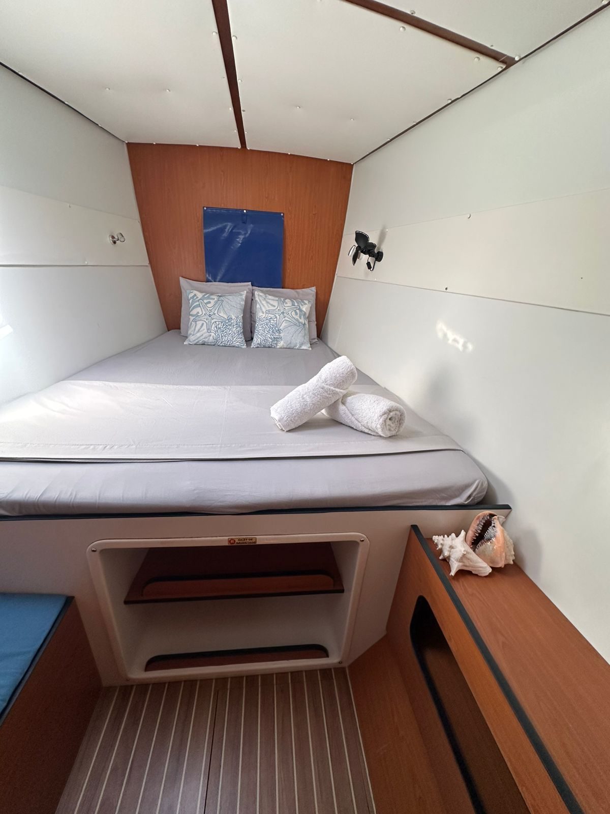 Double cabin with white linen, reading light and storage step