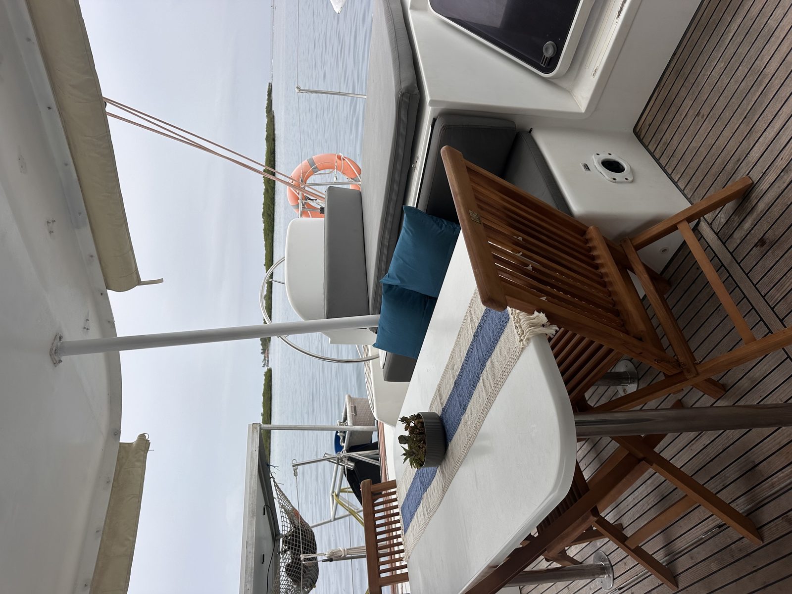 Teak folding chairs in the shaded cockpit alongside the guardrail
