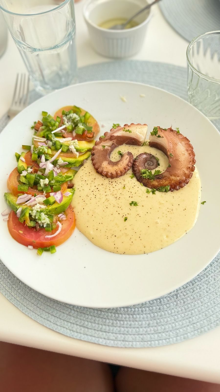 Octopus served with couscous and fresh tomato salad