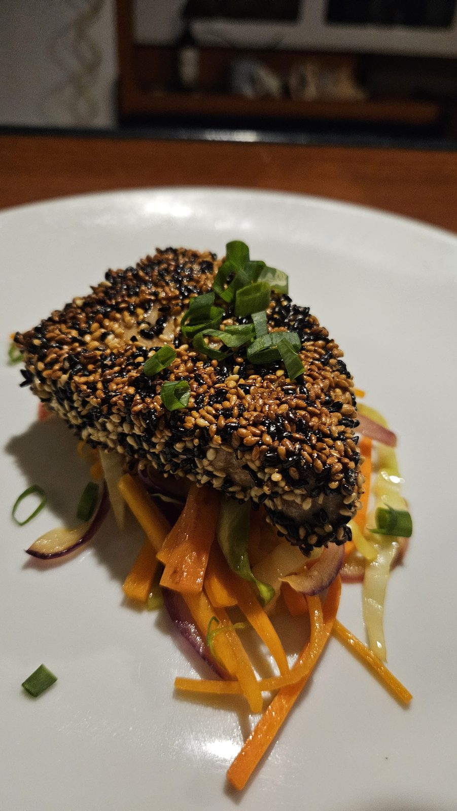 Sesame-crusted fish fillet on a bed of julienne vegetables