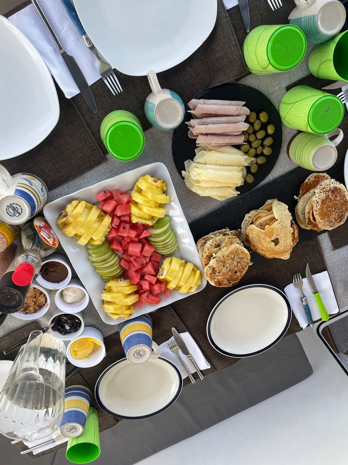 Breakfast spread with fresh fruit, pastries, eggs and juices