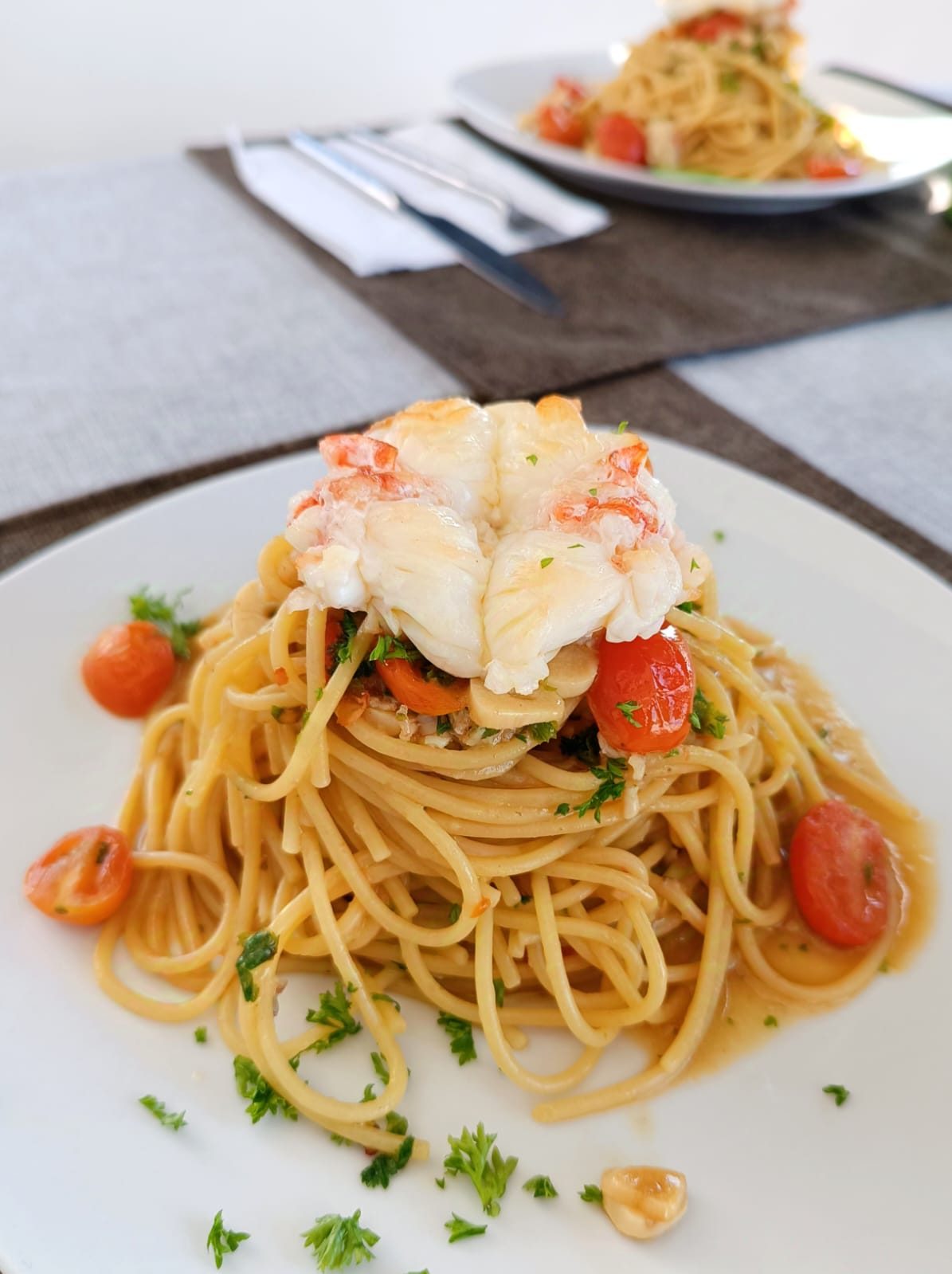 Spaghetti with lobster and cherry tomatoes served on board