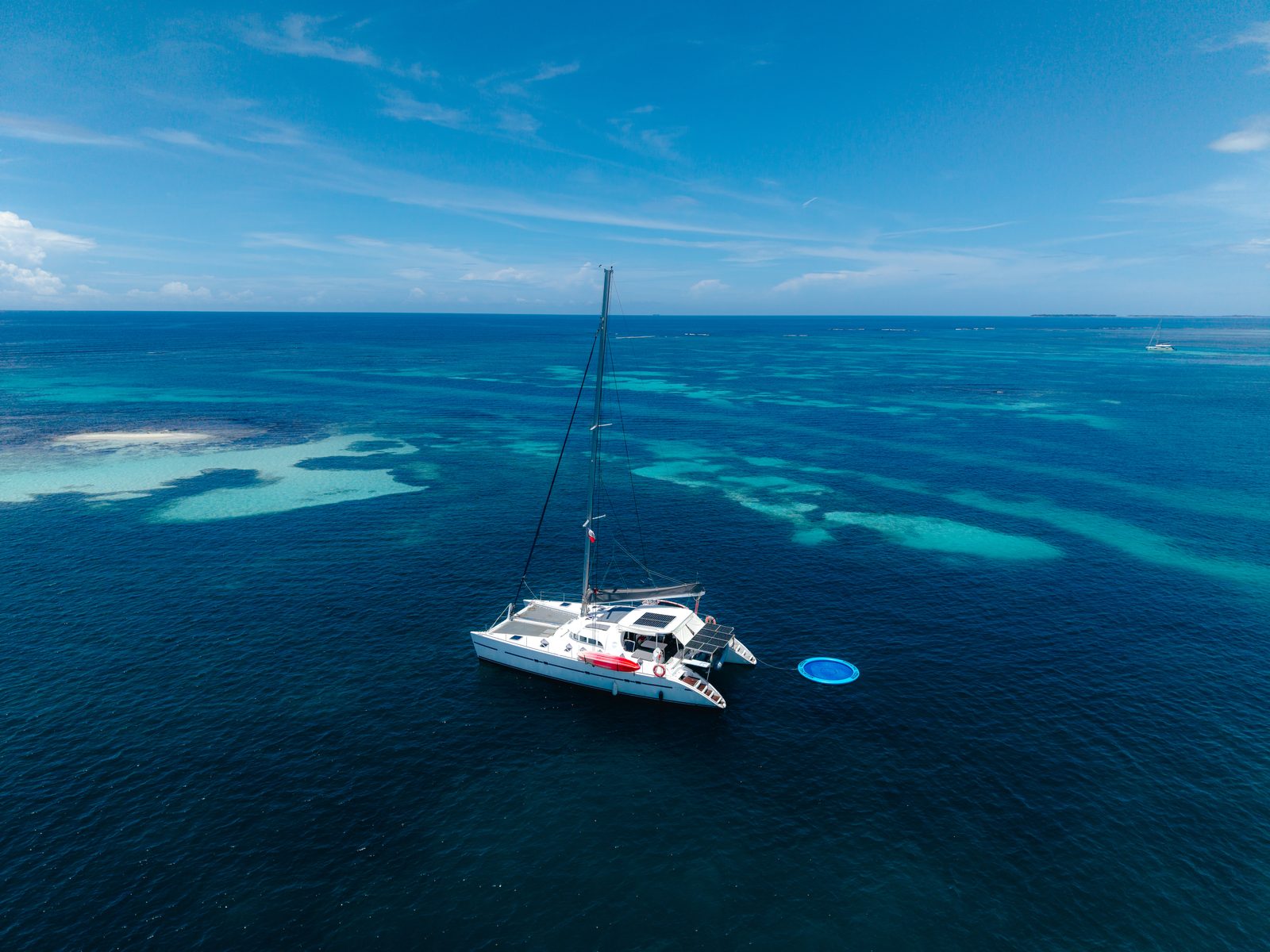 Aerial view of the catamaran anchored over turquoise shallows