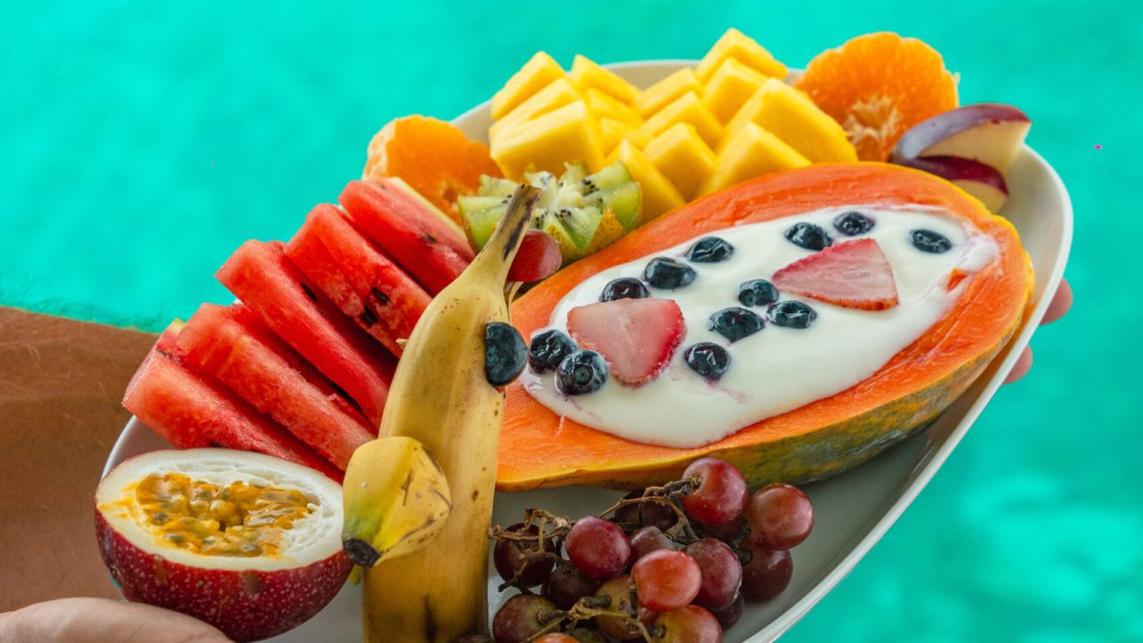 “Tropical breakfast of fresh fruits and yogurt served on a sailing yacht in San Blas, Panama with clear turquoise water in the background”